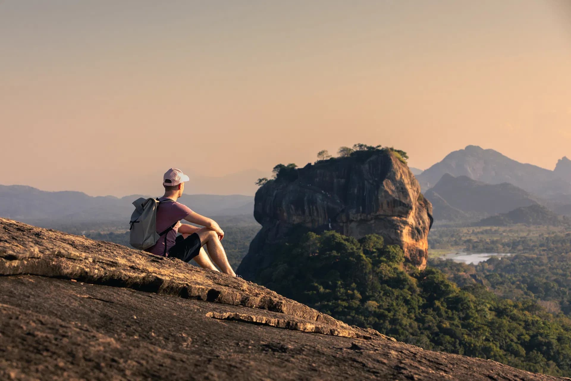 Hiker with backpack overlooking a scenic mountain landscape